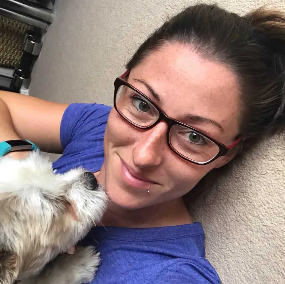 Woman smiling with dog indoors.